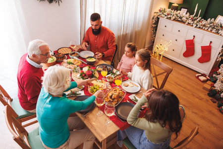 High angle view of happy multi-generation family gathered around the table, having Christmas dinner all together at homeの写真素材