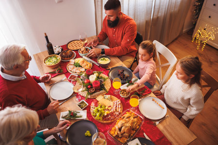 High angle view of happy multi-generation family gathered around the table, having Christmas dinner all together at homeの写真素材