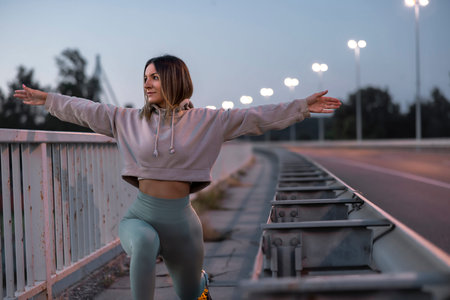 Active fit young woman in sportswear stretching out and warming up for morning jogging at dawnの写真素材