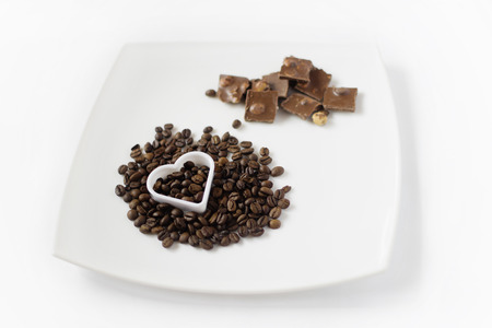 Plate with coffee and chocolate and baking tins in the form of heartの写真素材