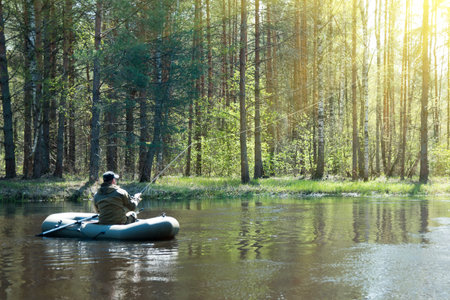 A fisherman in a boat on the riverの写真素材