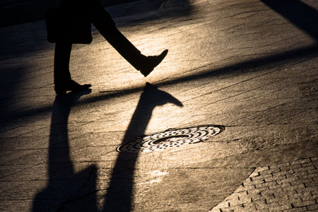 Silhouette and shadow of a people walking on a city sidewalkの写真素材