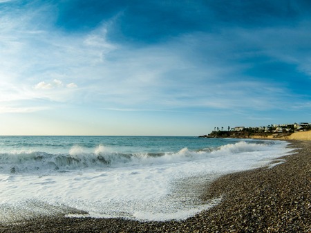 View of the beautiful sunset over the sea with wild pebble beach coastの写真素材