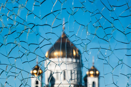 Golden dome on top of orthodox chapel through broken glass