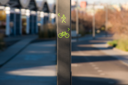 Direction sign for pedestrians and cyclists in city public park laneの写真素材
