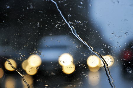 Bad weather driving traffic jam on a road, selective focus on raindrops on the windshield. Blurred backgroundの写真素材