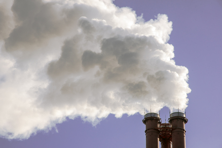 industrial factory pipes smoke at the sun on blue sky. ecology problemsの写真素材