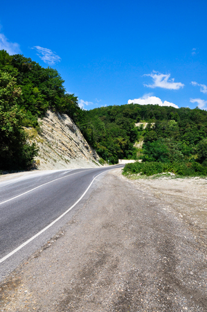 Wide angle vertical view of serpentine asphalt road in the mountainsの写真素材