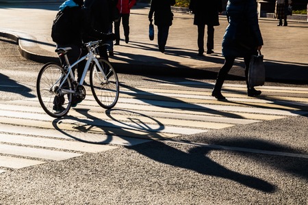 Shadows and silhouettes of people crossing zebraの写真素材