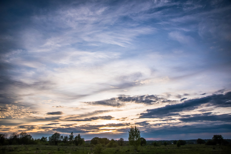 Summer sunset with dramatic sky and spindrift cloudsの写真素材