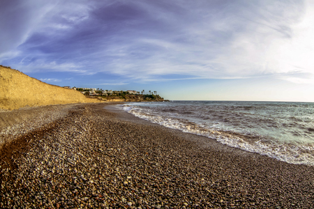 View of the beautiful sunset over the sea with wild pebble beach coastの写真素材