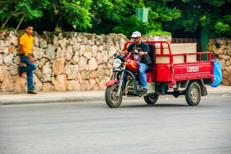 Punta Cana, Dominican Republic - September 17, 2014: Local men riding motorcycle on street of Punta Canaのeditorial素材