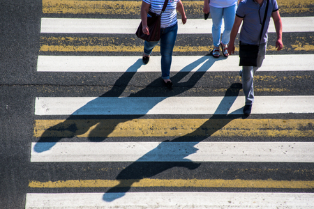 People and their long shadows on pedestrian crossingの写真素材