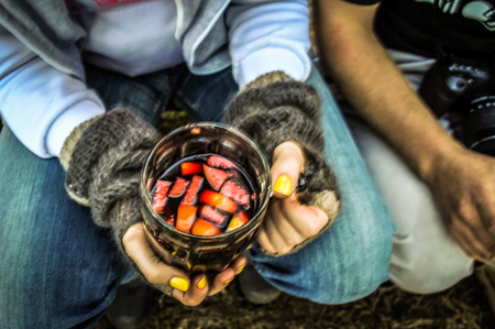 Top view of the girl's hands holding a big glass mug with hot mulled wineの写真素材