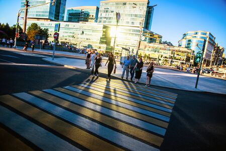 Russia, Moscow - 10 July 2018: Crowd anonymous people with long shadow walking on zebra crossingのeditorial素材