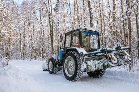 Old tractor clean snow in public parkの写真素材