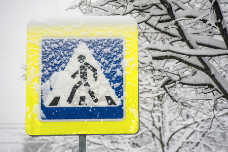 Pedestrian crossing traffic sign after snow stormの写真素材