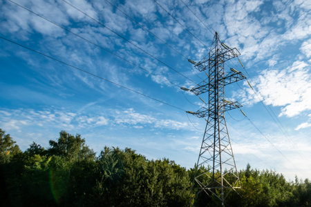High voltage electric tower on sunny day with cirrus clouds