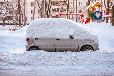 parked car covered in snow after a snowfallの写真素材