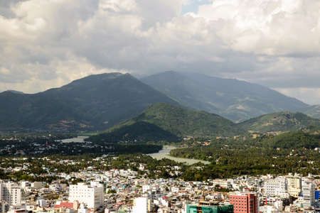View of urban cityscape with mountain and river background in a sunny dayの写真素材