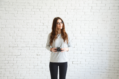 Flirtatious woman posing for a photographer with a cameraの写真素材