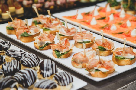 Tasty snacks with salted salmon and cottage cheese filling on square plateの写真素材
