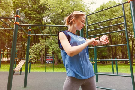 Woman using activity tracker at gym measure the pulseの写真素材