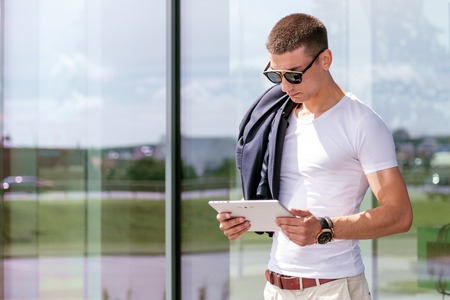 Young fashionable wearing a freelancer working on the tablet.の写真素材