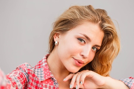 Young beautiful blonde woman photographed themselves on mobile phoneの写真素材