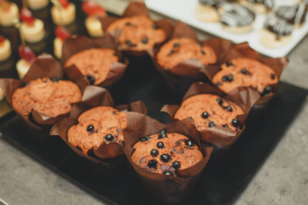 Freshly baked honey raisin muffins in rustic setting. Vintage pewter dishes with ingredients in...