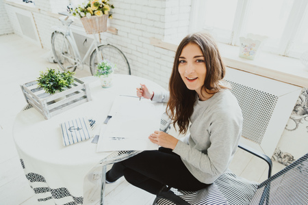 Portrait of a happy girl freelance designer in the workplace.の写真素材