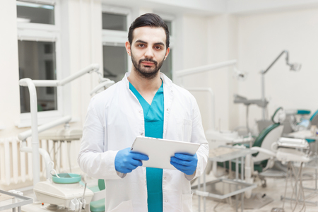 Portrait of young modern doctor dentist with electronic tabletの写真素材