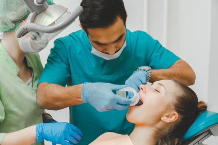 Doctor dentist puts the retractor to the patient.の写真素材