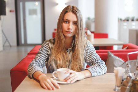 Beautiful woman with long straight hair drinking teaの写真素材