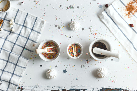 Three saucer in centre with spoons and candy sprinkles, surrounded by sweets. Top Viewの写真素材