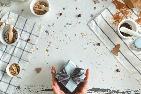Woman holding in hands christmas present with blue ribbon. Xmas concept. Top view.の写真素材