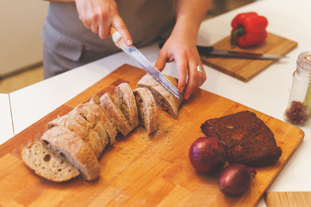 Female hands cutting a piece of wheat sweet bread. Top angle viewの写真素材