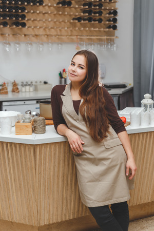 Portrait of beautiful young barmaid in apronの写真素材