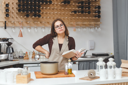 Young woman cooking soup in the kitchenの写真素材