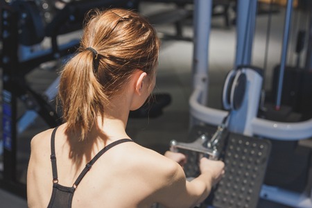 Girl in the gym develops the muscles of the backの写真素材
