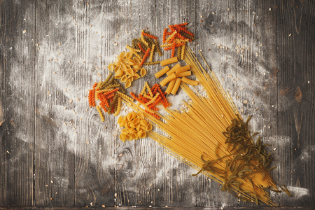 Art composition of bouquet of flowers made of different types of pasta on a black wooden background. Top viewの写真素材