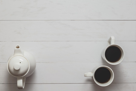 Tea still life with kettle and two cups on white wooden desk.の写真素材