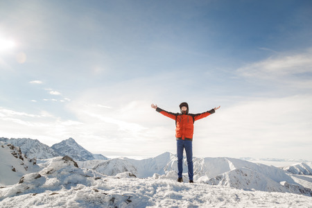 Man on the top of the world raised his hands proud of his achievements.の写真素材