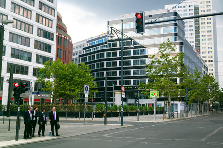 Berlin, Germany - September 7, 2014. Mens businessmen in the same business suits with cases in the business quarter are crossing the streetのeditorial素材