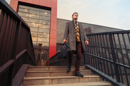 Office fashionably dressed young business man with a briefcase walking through the city