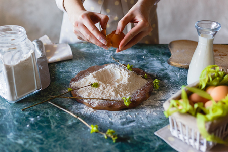 Close up view of baker kneading dough. Homemade bread. Hands preparing bread dough on wooden table. Woman hands kneading fresh dough for making bread.の写真素材
