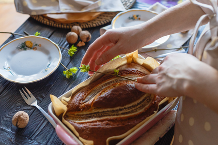 Baker woman is decorating banana pie by spring branchの写真素材