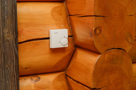 Room temperature controller for heating and cooling on a wall in a wooden houseの写真素材