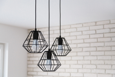 A modern loft chandelier made of black wire in a stylish white interiorの写真素材