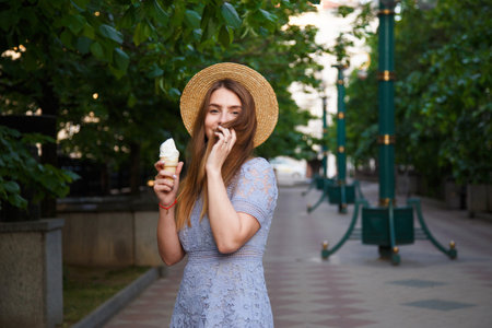 Young caucasian woman in summer hat enjoying the ice cream.の写真素材